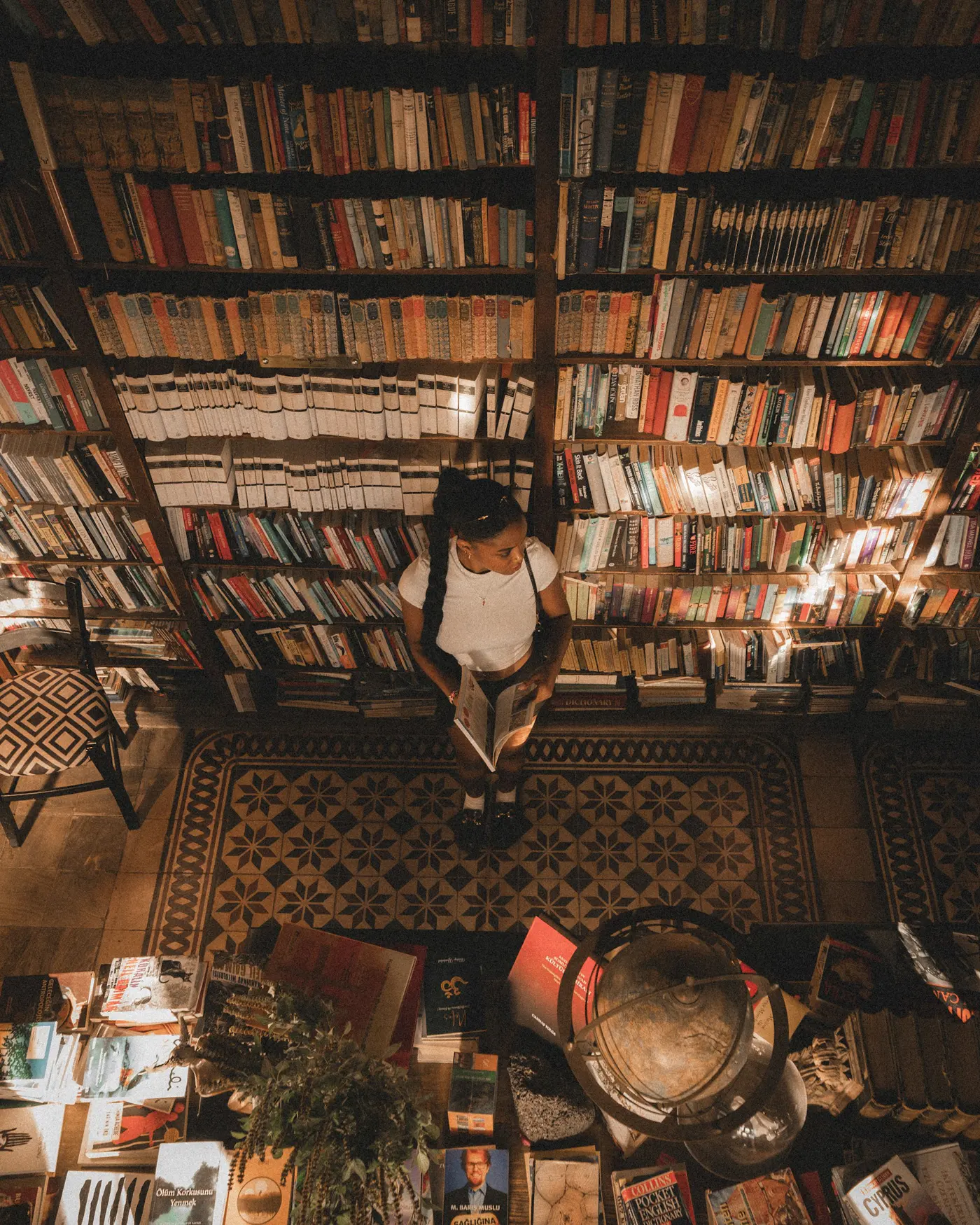 A person reading in a library filled with books